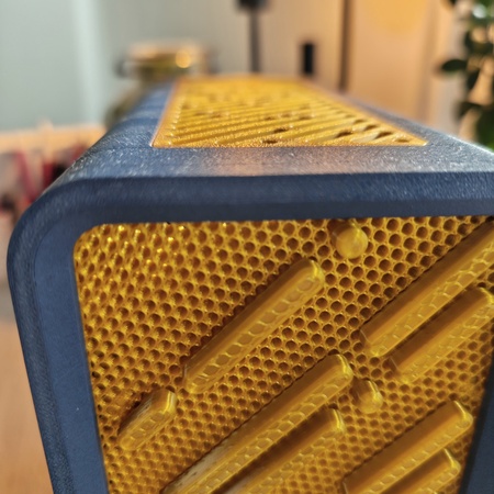 Detail: gelbes Wabengitter und Rahmenkante